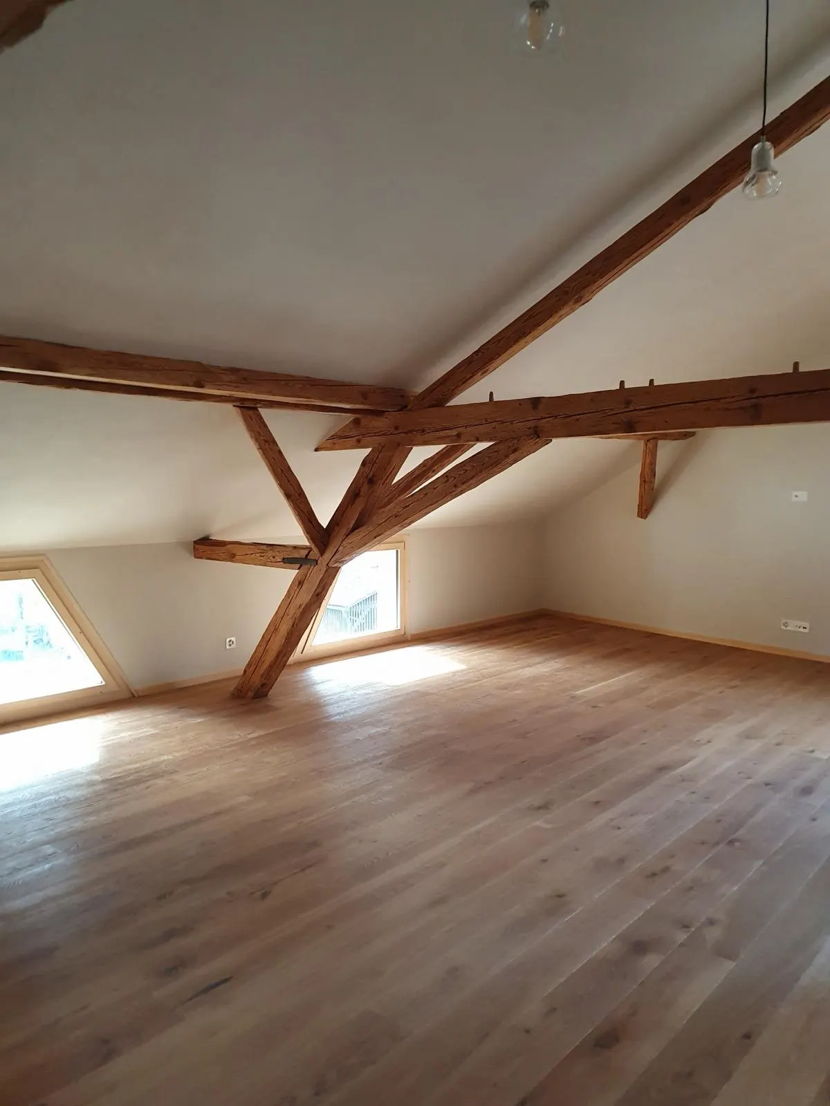 Referenzobjekt — Dachzimmer mit freigelegten Holzbalken und hellem Anstrich